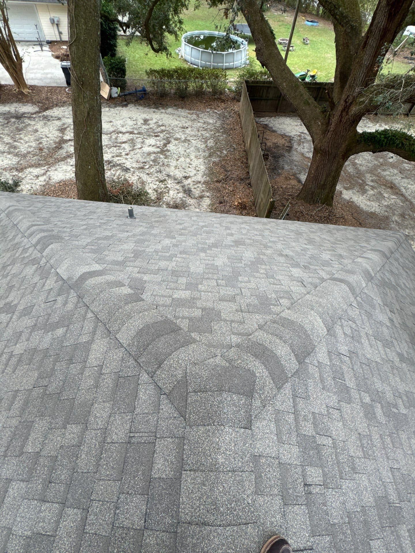 Gray shingle roof, view of tree and backyard. Gray shingle roof, view of tree and backyard.
