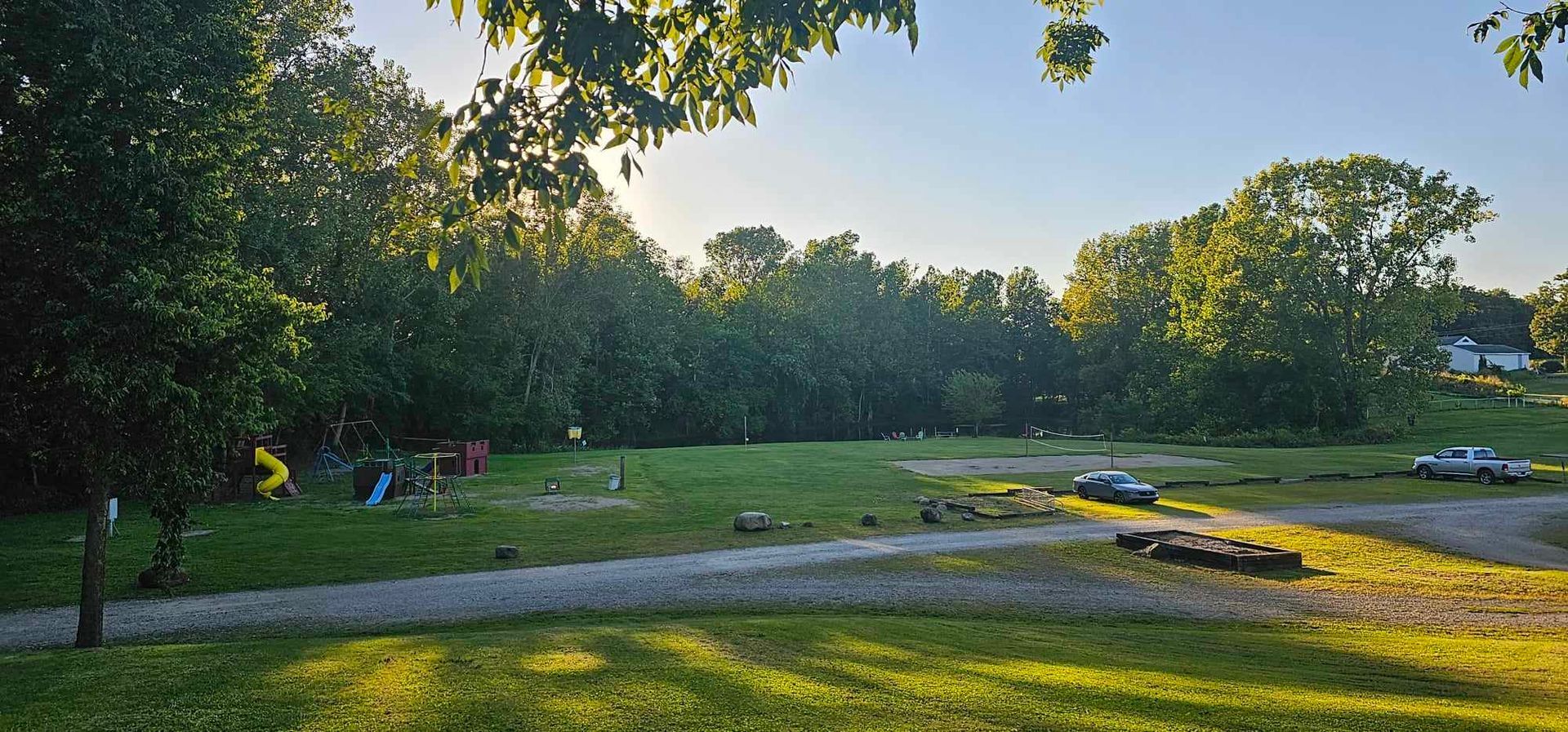 a car is parked in a grassy area near a playground