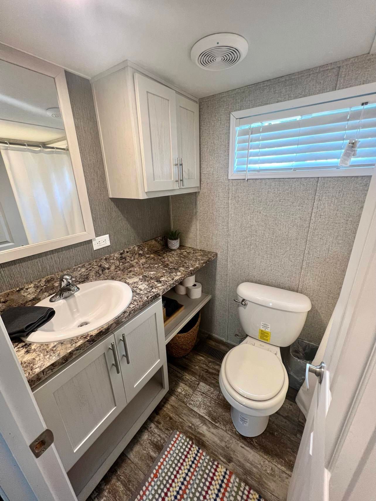 a bathroom with a toilet a sink and a window
