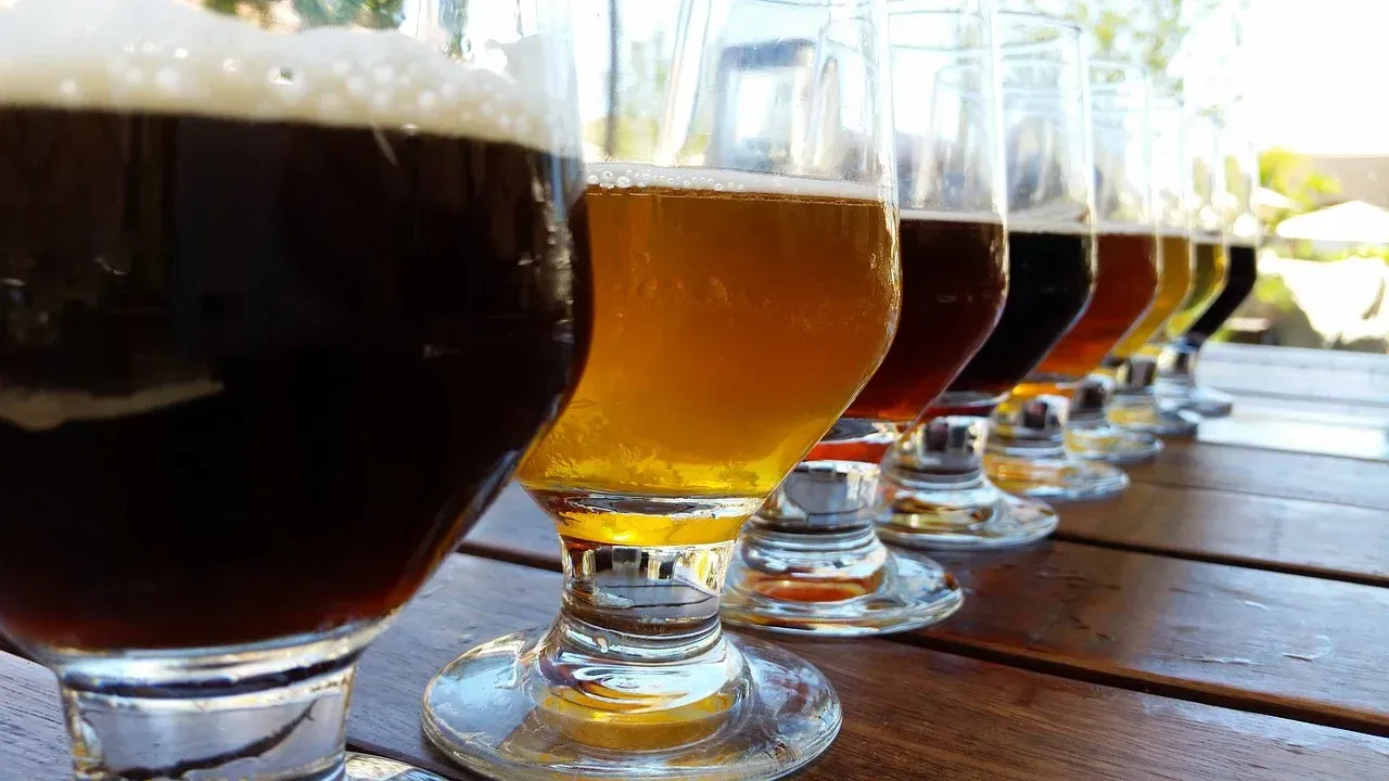 a row of glasses filled with different types of beer