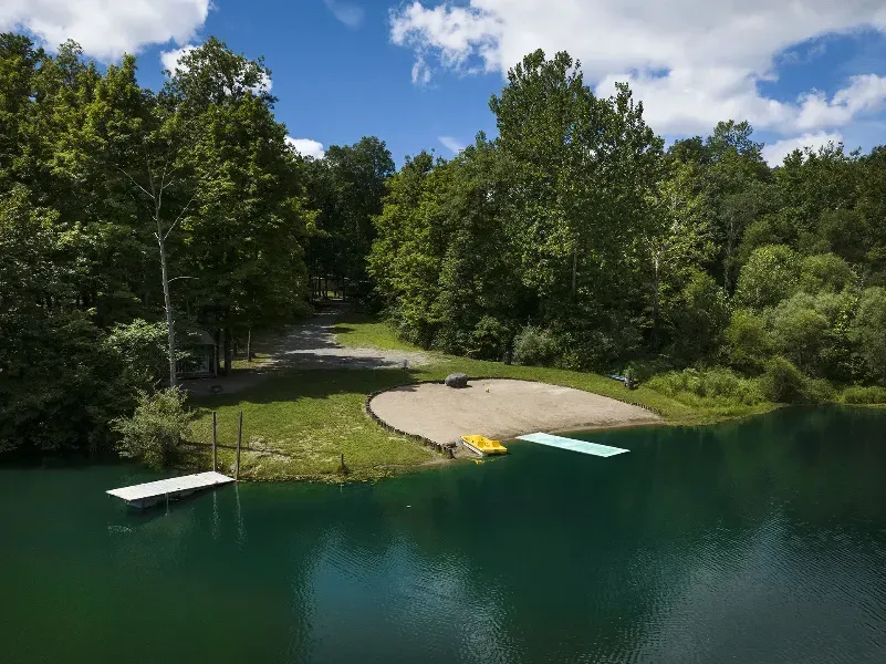 an aerial view of a lake with a sandy beach