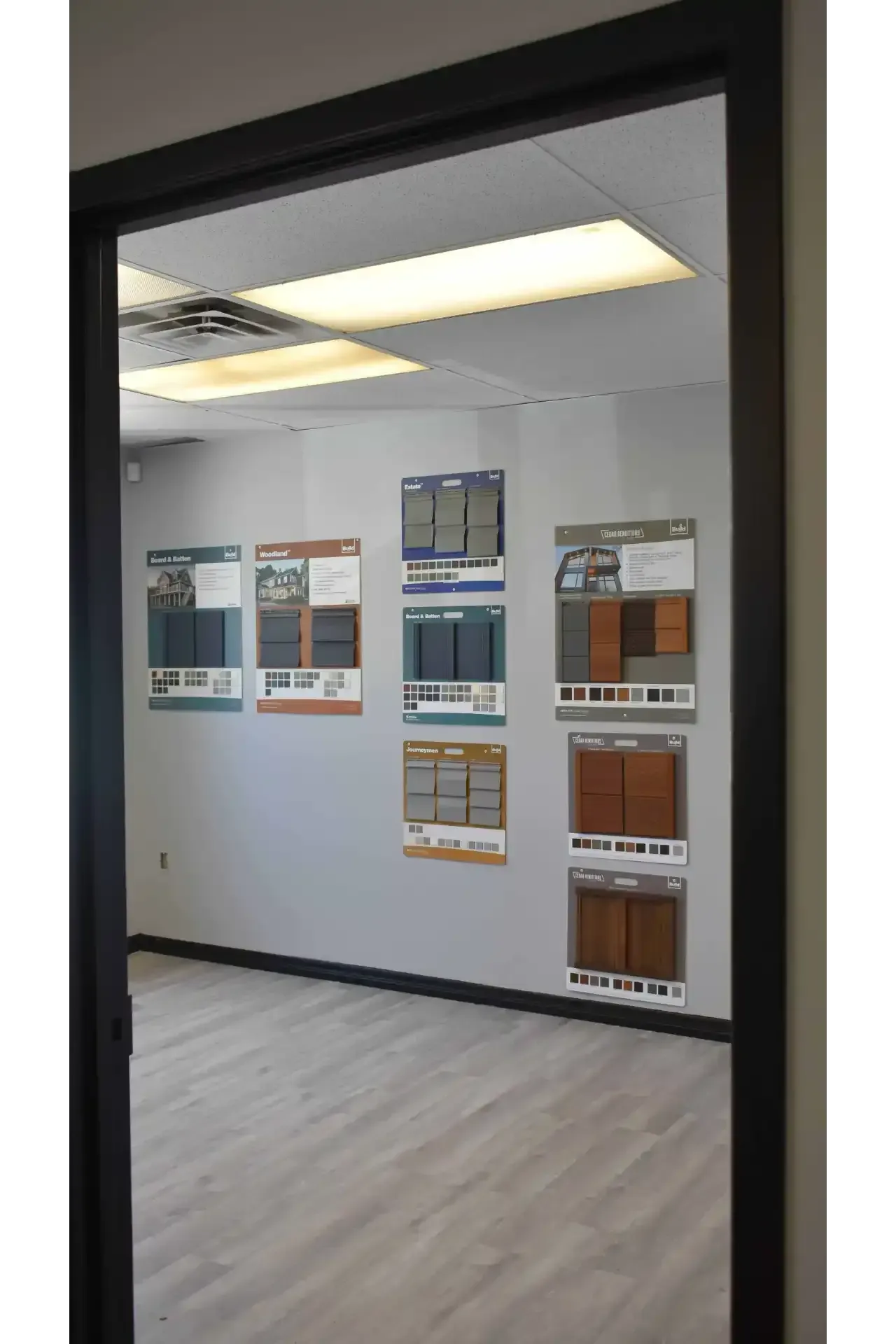 View through a doorway of a room with cabinet sample posters on the wall.