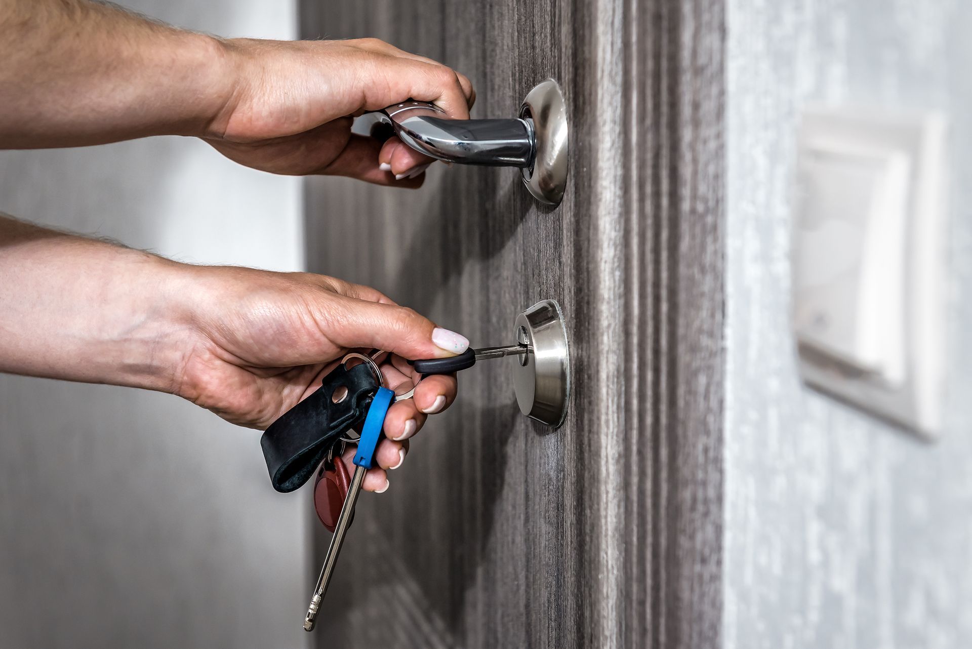 A person is opening a door with a key.