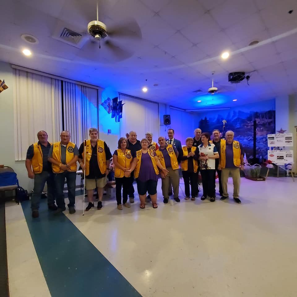 A group of people in yellow vests are posing for a picture