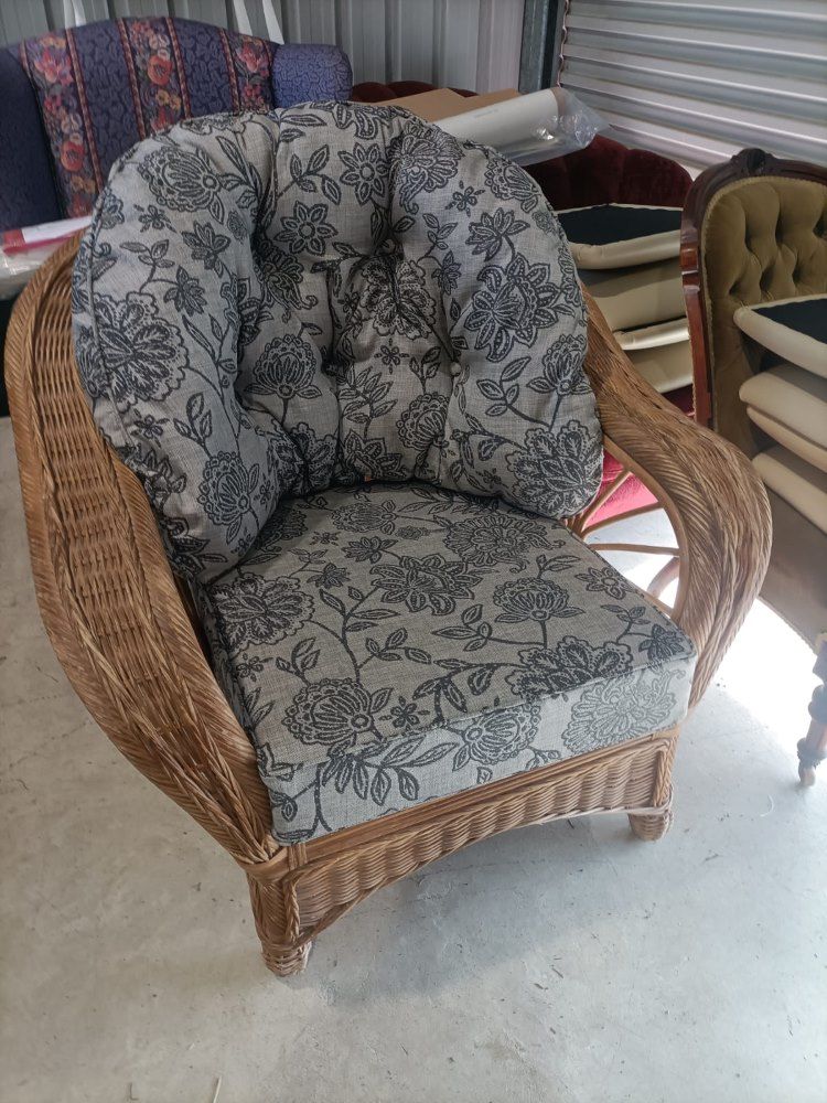 A Wicker Chair With A Cushion On It Is Sitting On A Cement Floor — Ocean Charm Upholstery In Southport, QLD