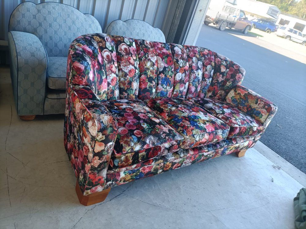 A Colorful Couch With A Floral Pattern Is Sitting In A Garage Next To A Chair — Ocean Charm Upholstery In Southport, QLD