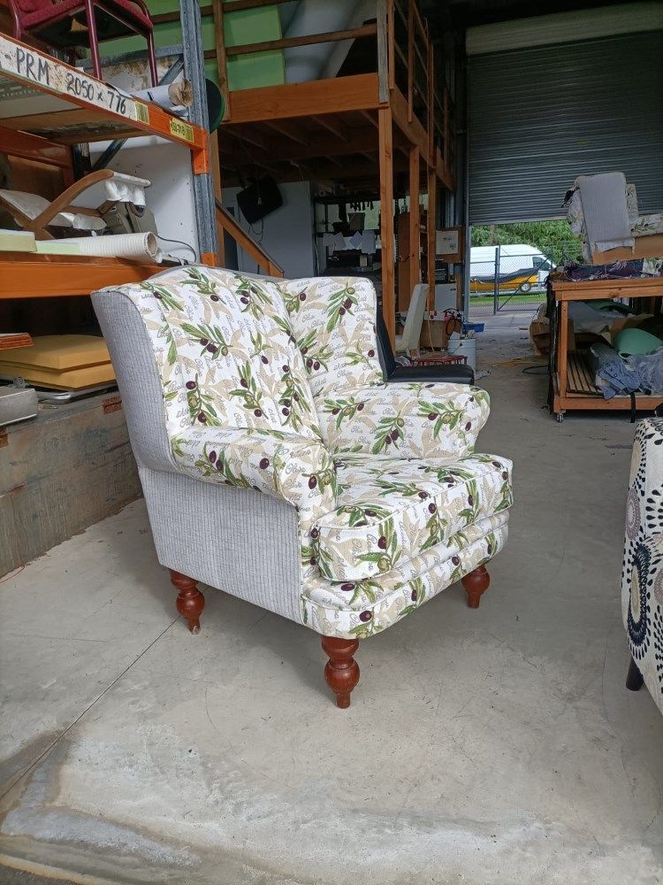 A Chair With A Floral Pattern Is Sitting In A Warehouse — Ocean Charm Upholstery In Southport, QLD