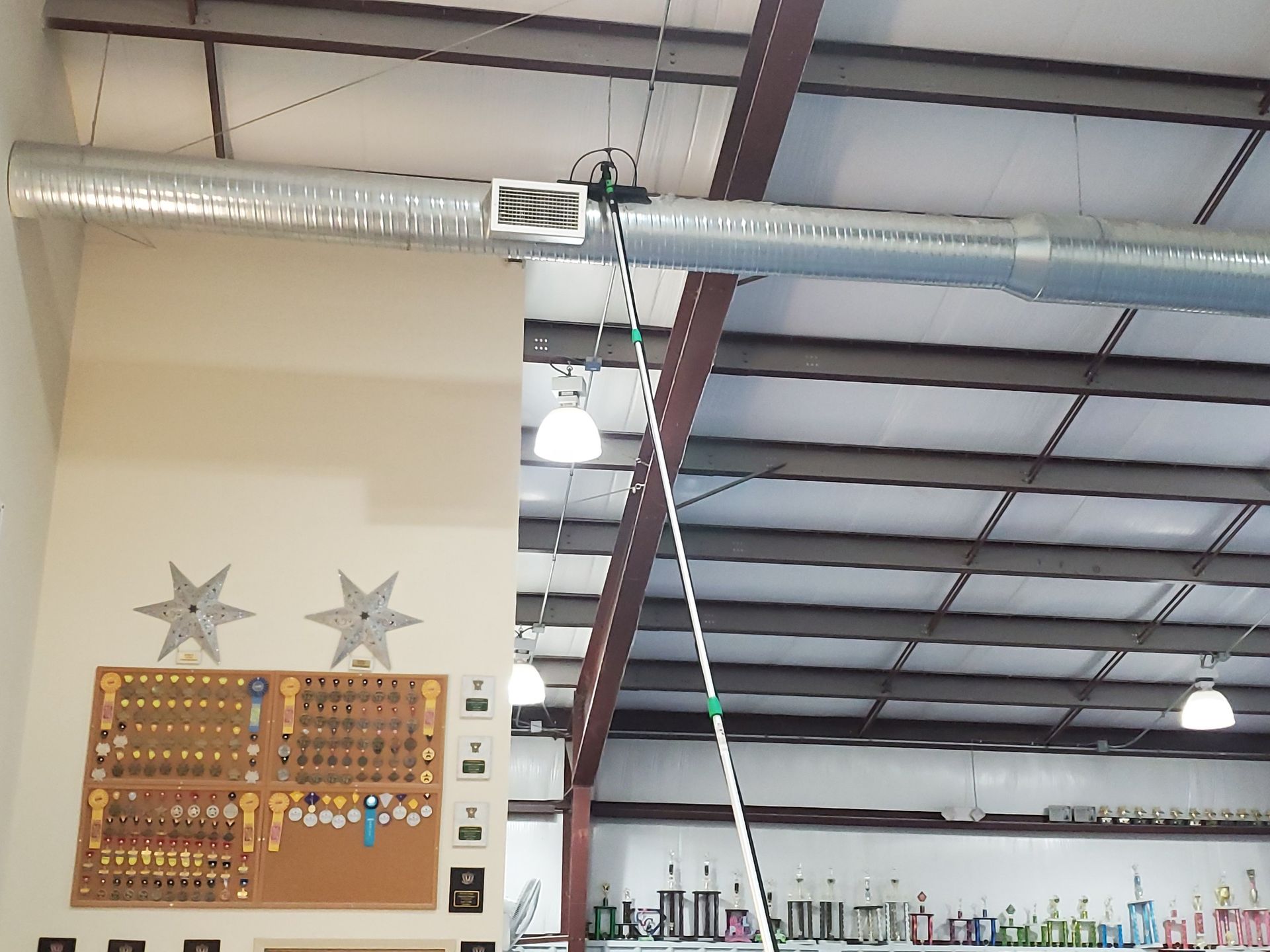 Interior view of a building with a key display board on a white wall. Metal beams and ductwork are visible.