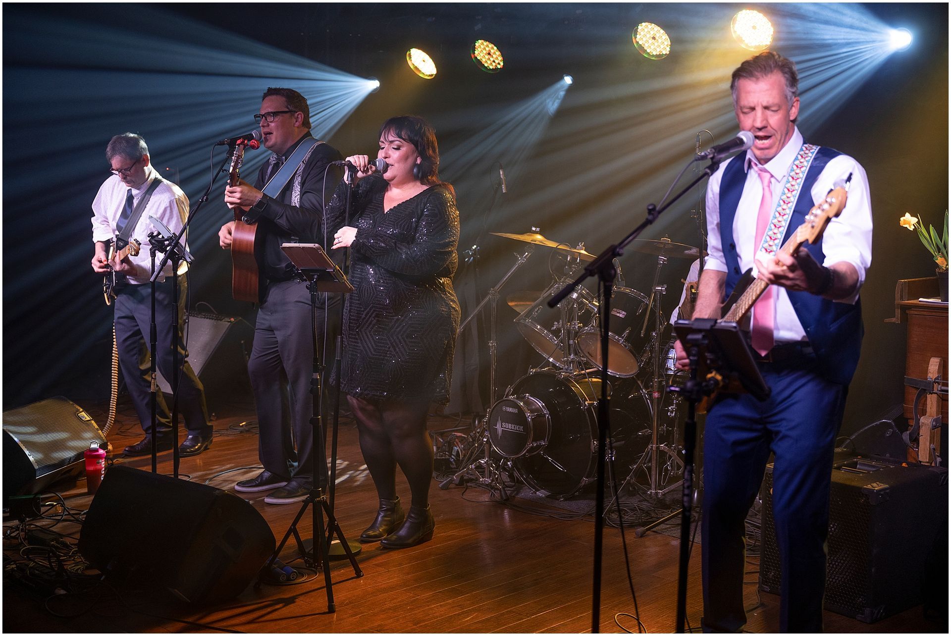 Band performing live on stage under spotlights.