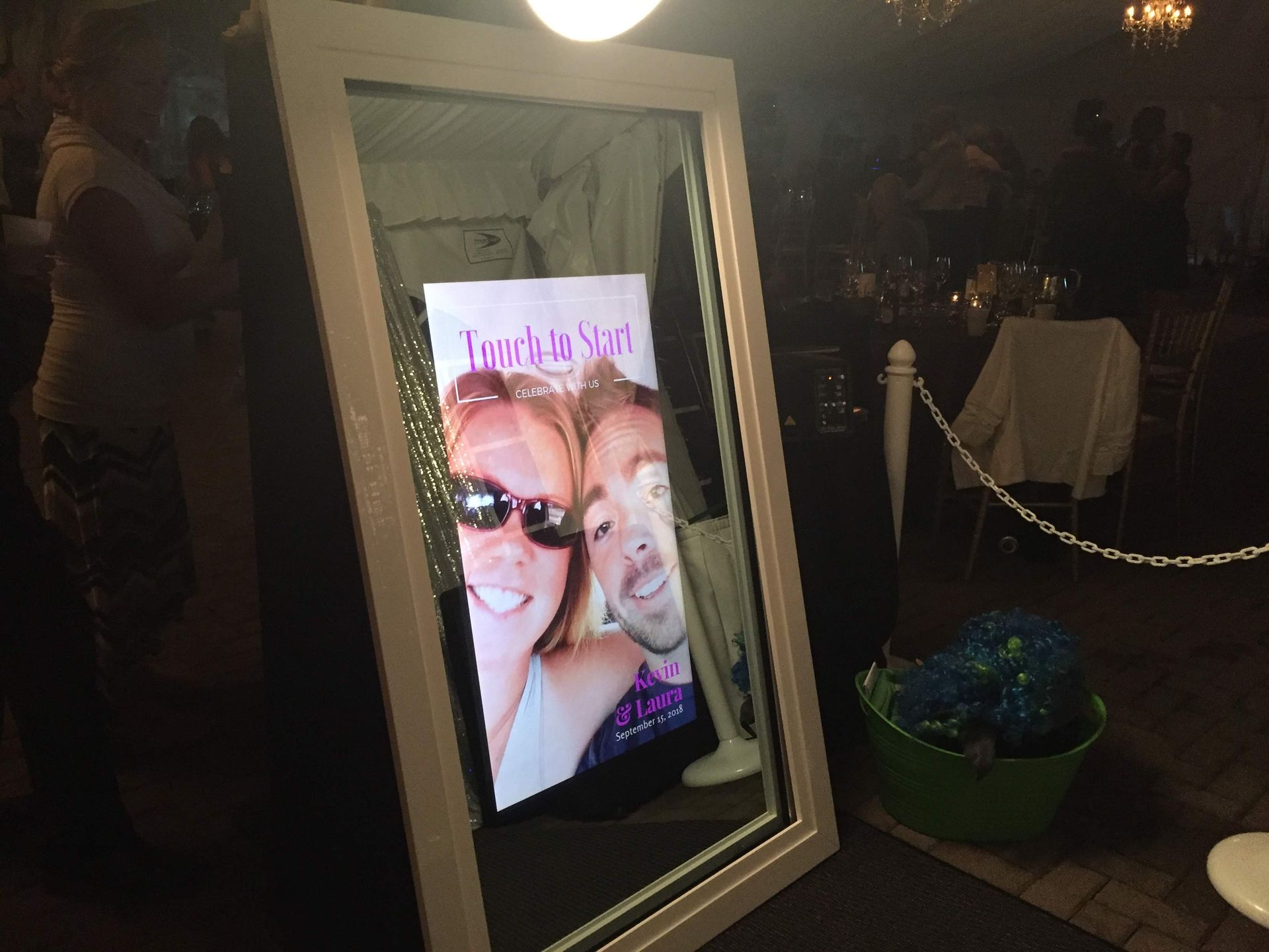 Photo booth mirror with a photo displayed, setting at an event.