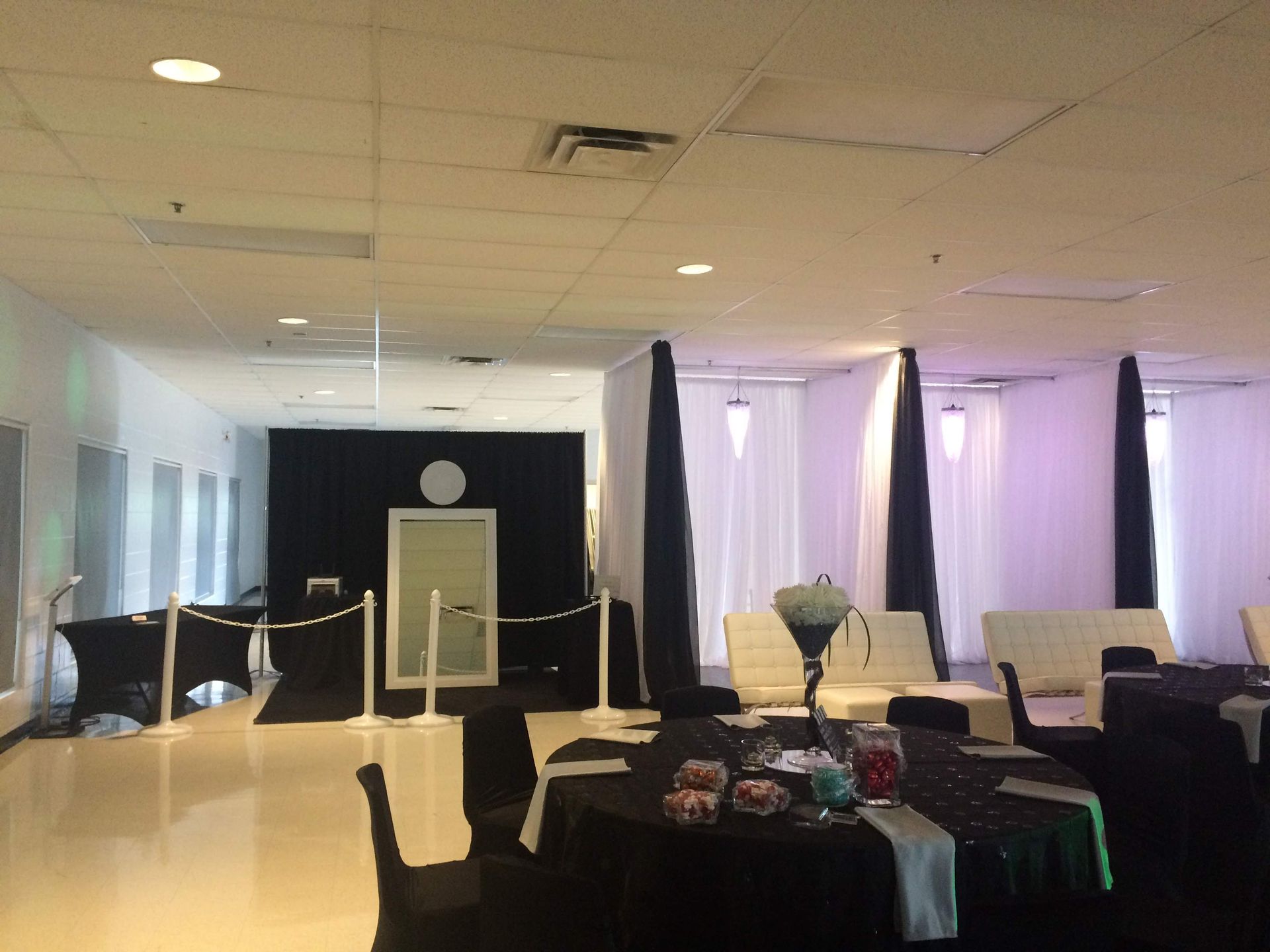 Event space with black and white decor; tables, seating, and photo booth.