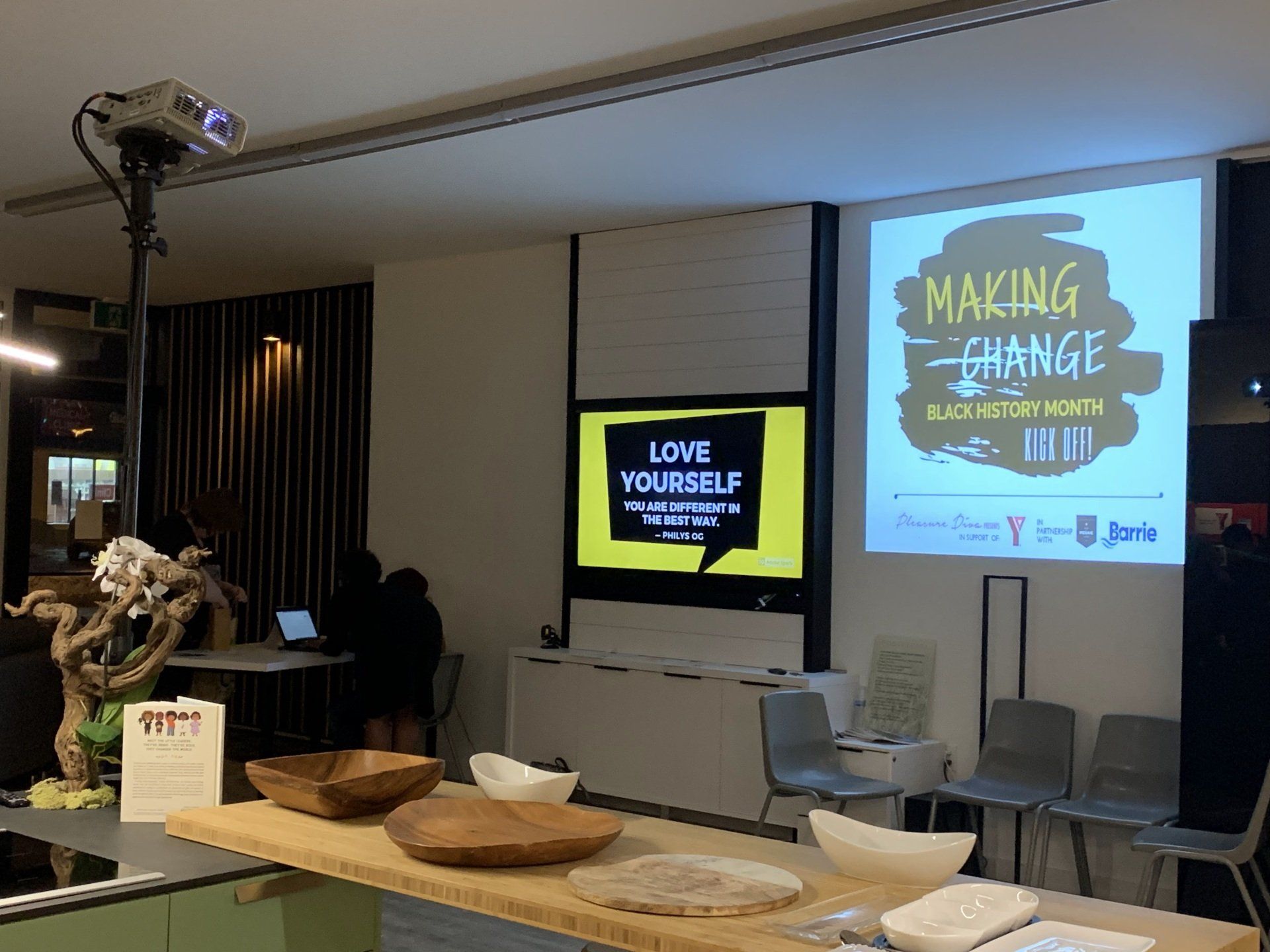 Interior view of a presentation room with event signage: 
