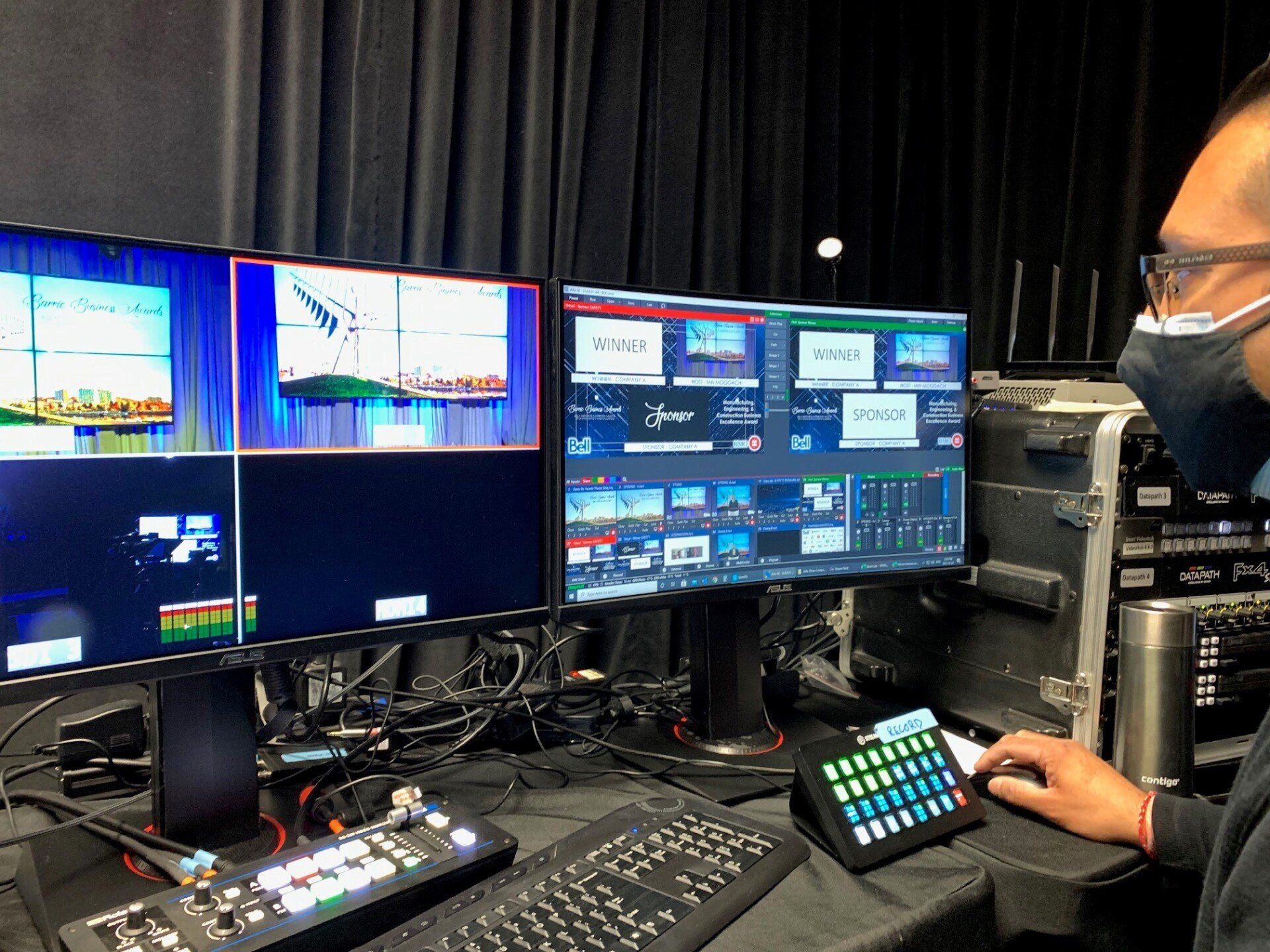Person operating video production equipment with monitors displaying a live broadcast.