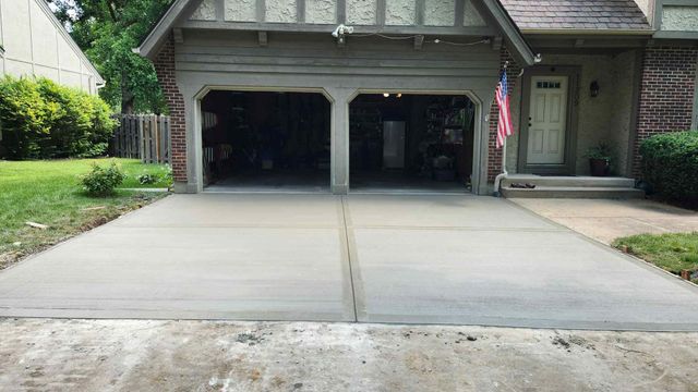 Suburban house with a wide concrete driveway and open two-car garage