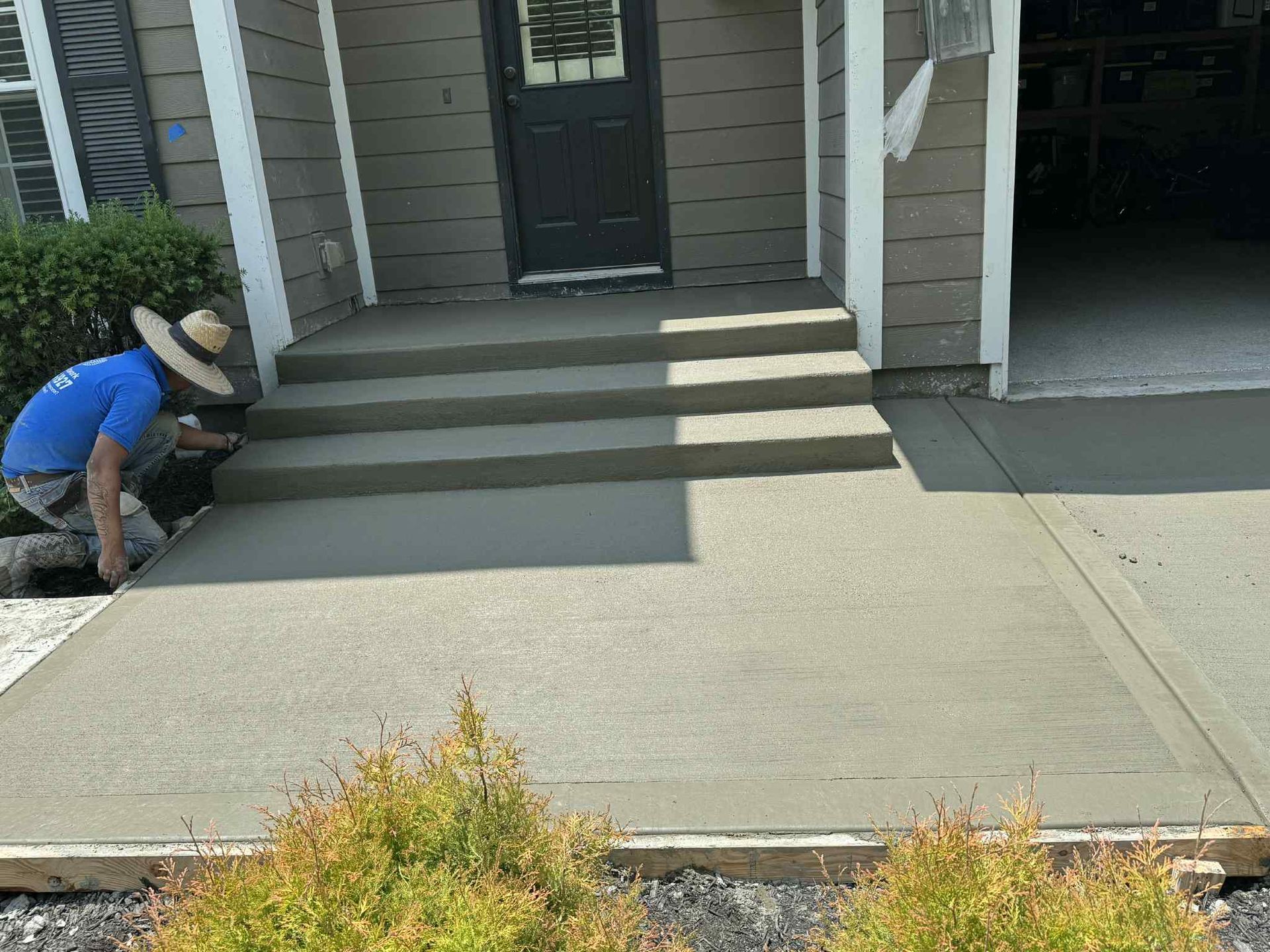 Worker smoothing concrete front porch steps