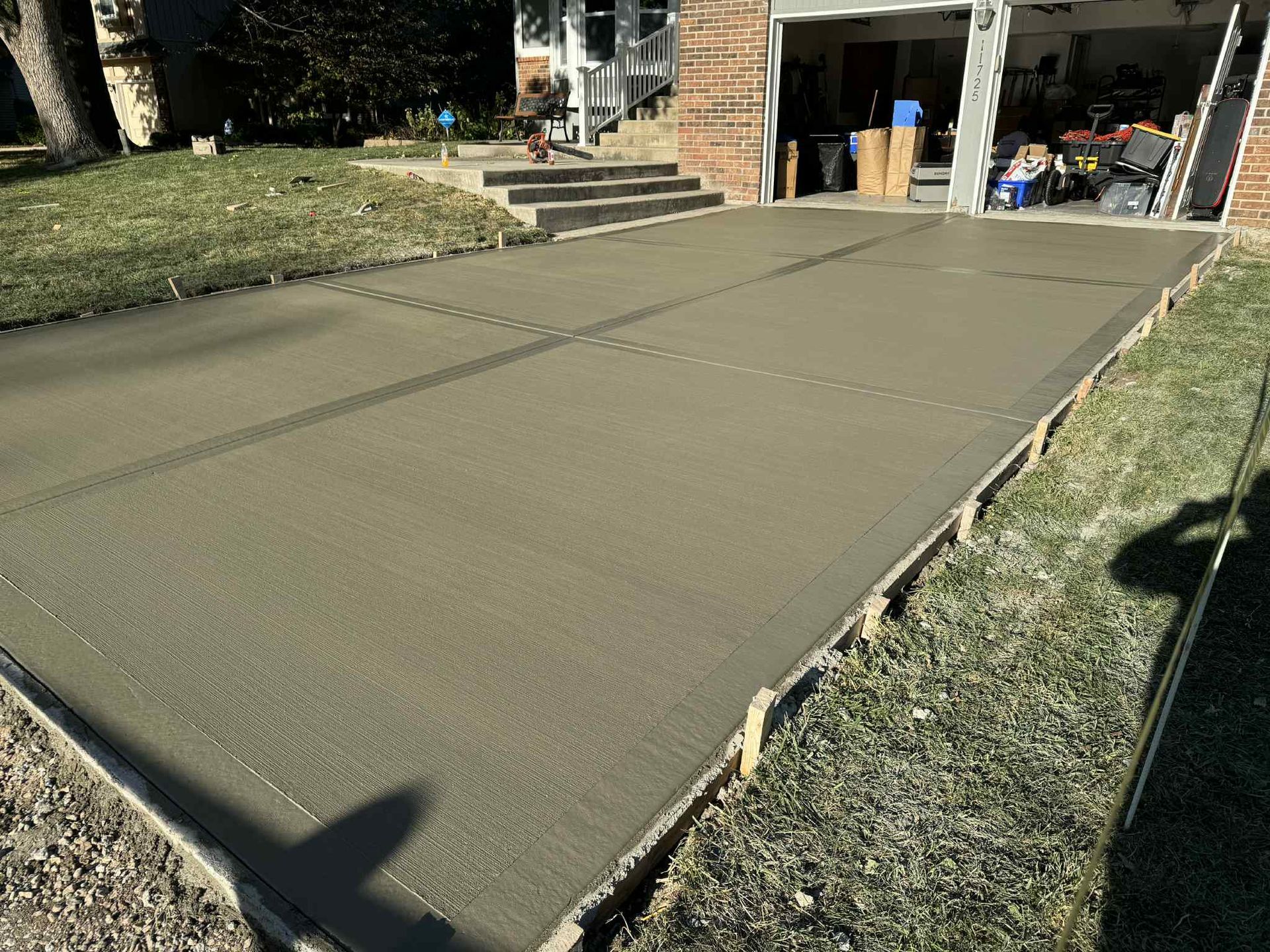 Freshly poured concrete driveway leading to a garage