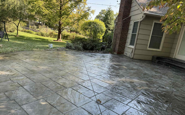 Wet stamped concrete patio beside a house