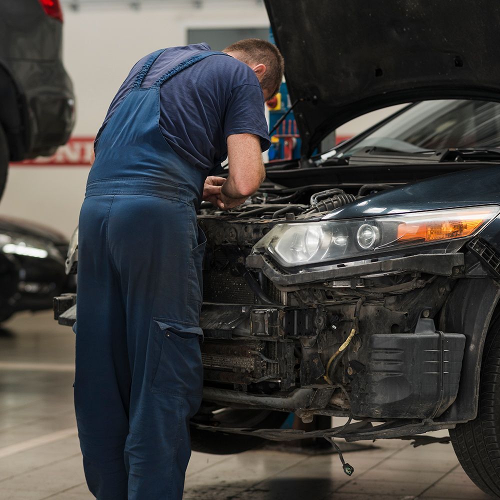A man is working under the hood of a car