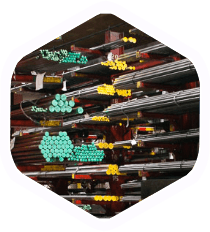 Stacks of colored metal pipes stored on industrial shelving in a warehouse-like setting