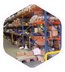 Warehouse aisle with blue-orange metal shelving and stacked boxes on pallets