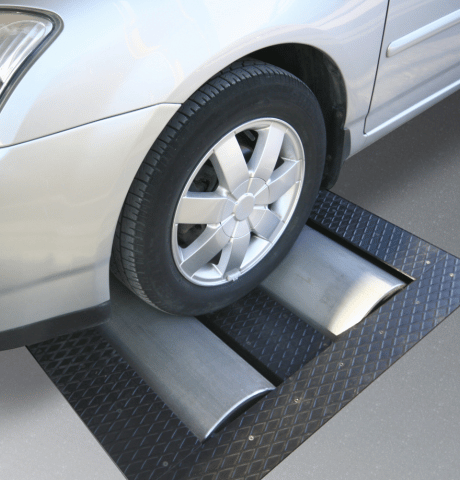 Vehicle wheel positioned on a dynamometer roller for performance testing.