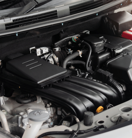 Close-up of a modern vehicle engine and surrounding components under the hood.