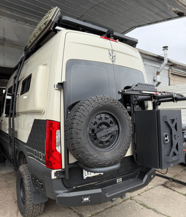 White commercial van equipped with an off-road spare tire and exterior accessories.