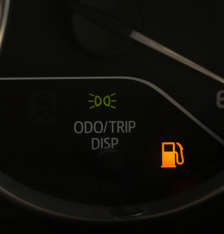 Dashboard displaying an illuminated low fuel warning light.