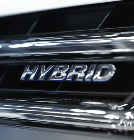 Close-up of a hybrid vehicle badge on the exterior of a car.
