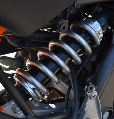 Close-up of a vehicle suspension coil spring and shock absorber assembly.
