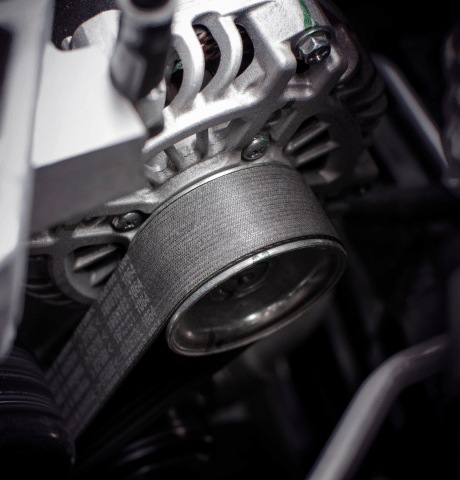 Close-up of an automotive timing belt running around an engine pulley.
