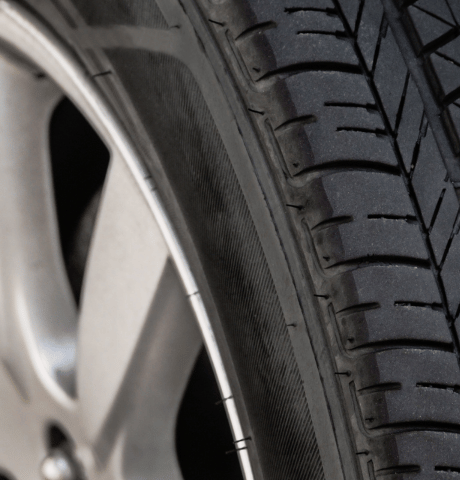 Close-up of a vehicle tire showing the tread pattern and sidewall.