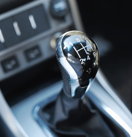 Close-up of a manual transmission gear shifter inside a vehicle.