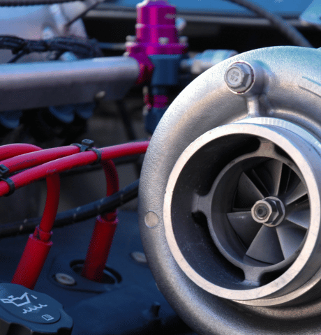 Close-up of a performance turbocharger installed in a vehicle engine bay.
