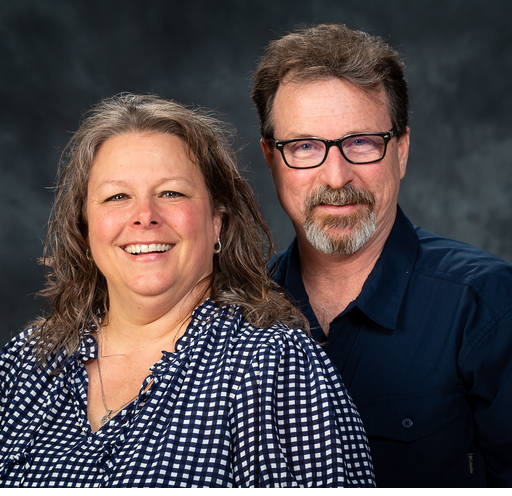 A man and a woman are posing for a picture together and smiling.