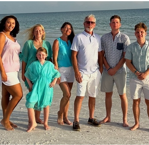 A group of people posing for a picture on the beach