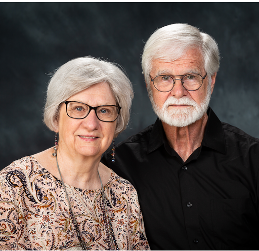 A man with glasses and a woman are posing for a picture together