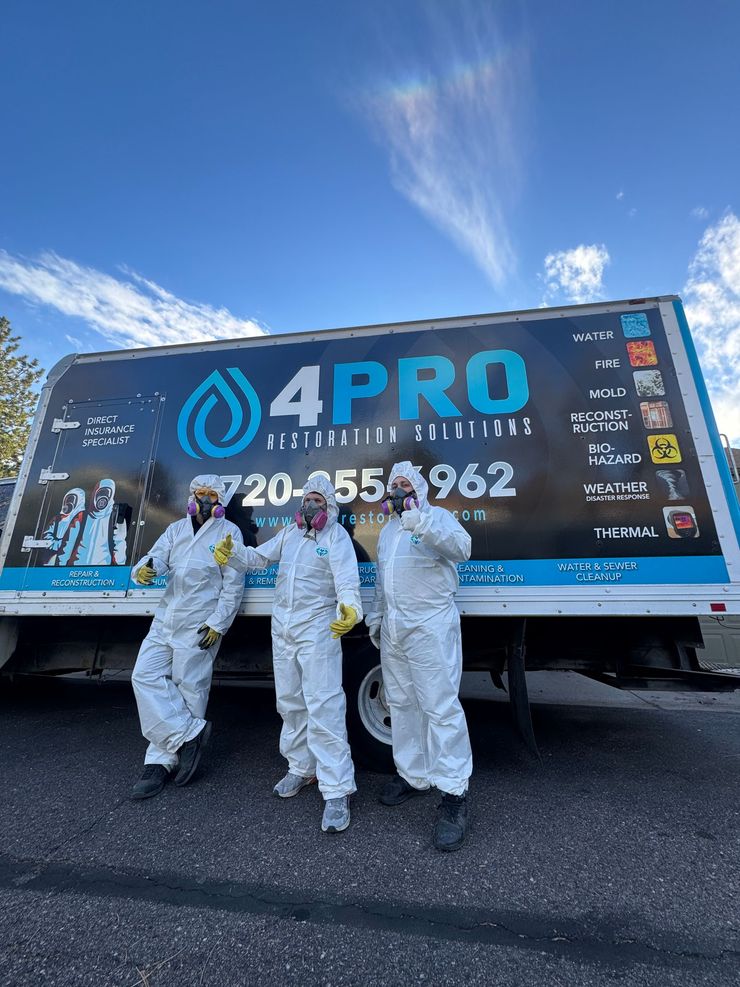 Three workers in white suits stand before a blue 4PRO truck under a bright sky.