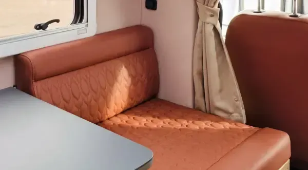 Ein Tisch in einem Wohnmobil mit braunen, strukturierten Sitzen