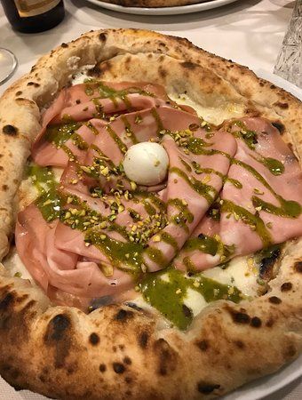 Una torta bianca con lamponi sopra è su uno scaffale del frigorifero.