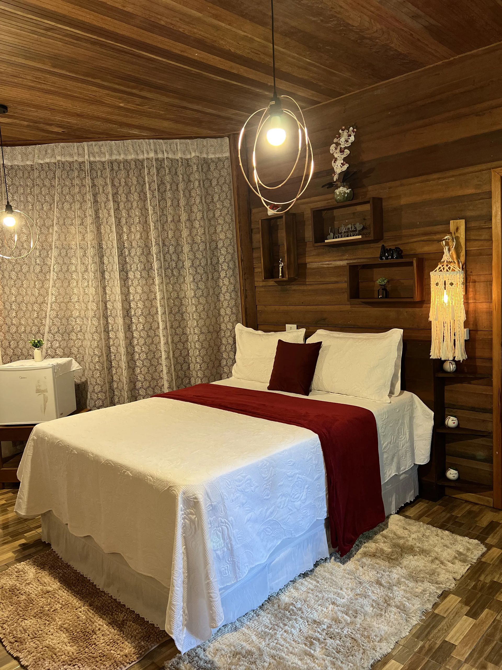 Uma pérgola de madeira com cortinas brancas e uma mesa. Pousada-Sumauma