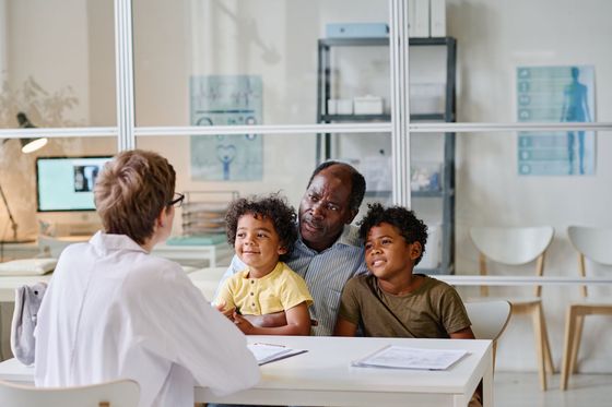 Doctor consulting with a family in a bright medical office