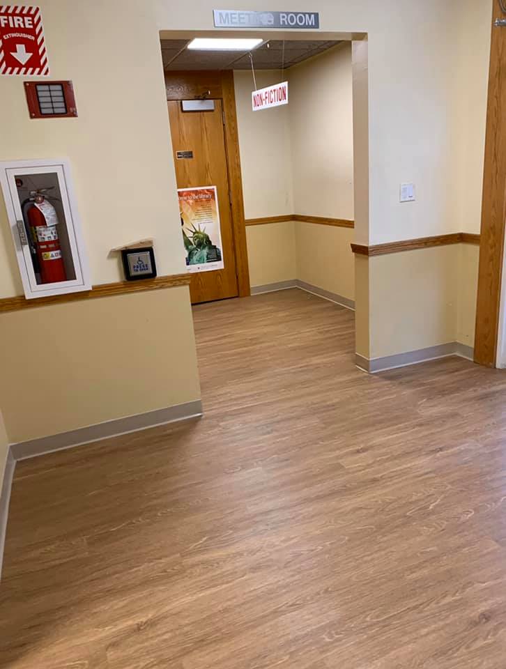 A hallway with wood flooring leading to a 