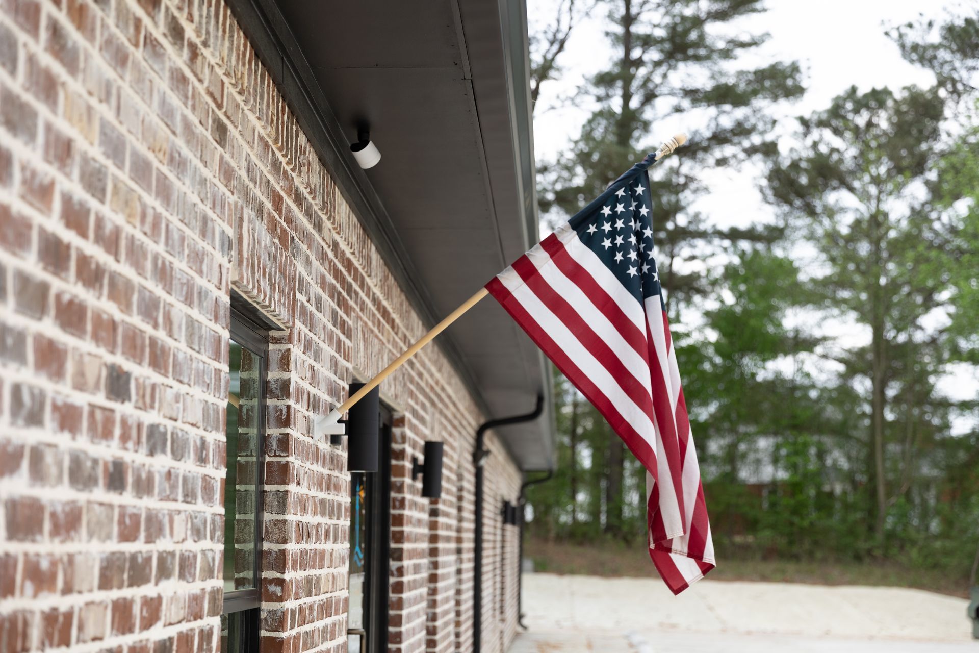 American flag waving outside a brick building.