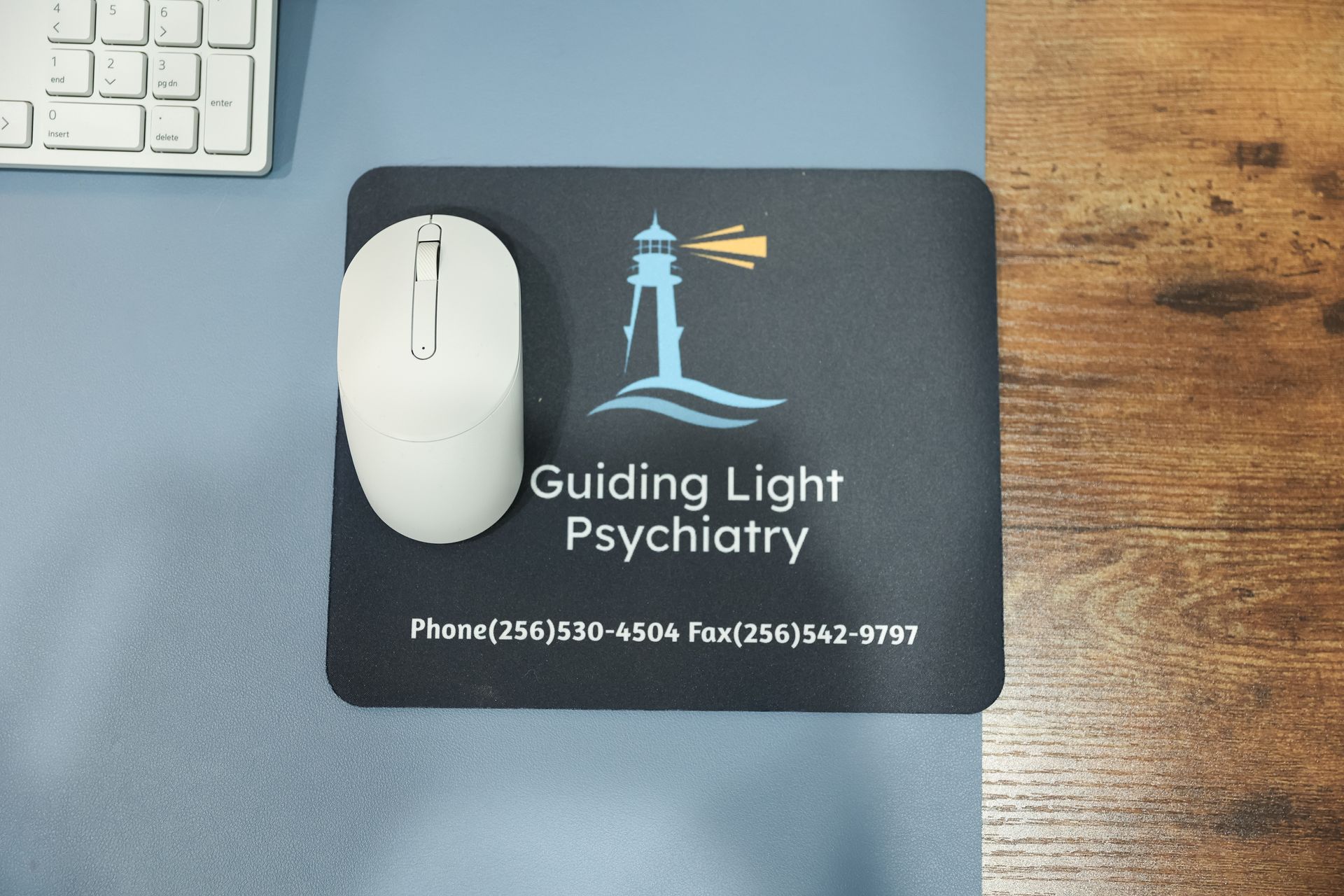 White mouse on a mousepad with a lighthouse logo for 