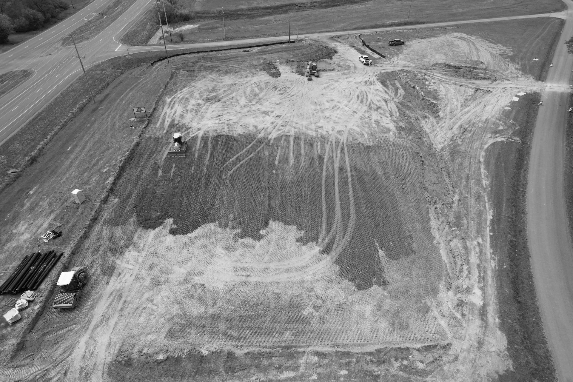 Overhead view of construction site with machinery, dirt, and road nearby.