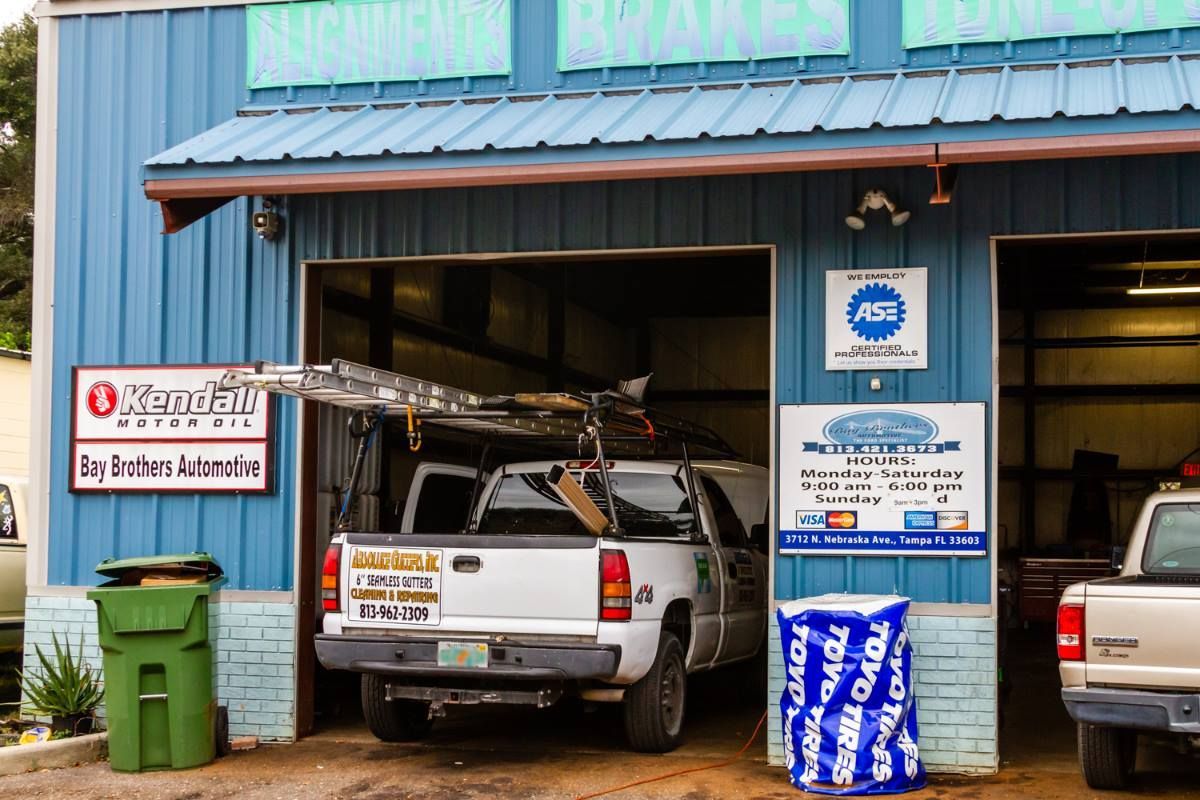 A white truck is parked in front of a blue building