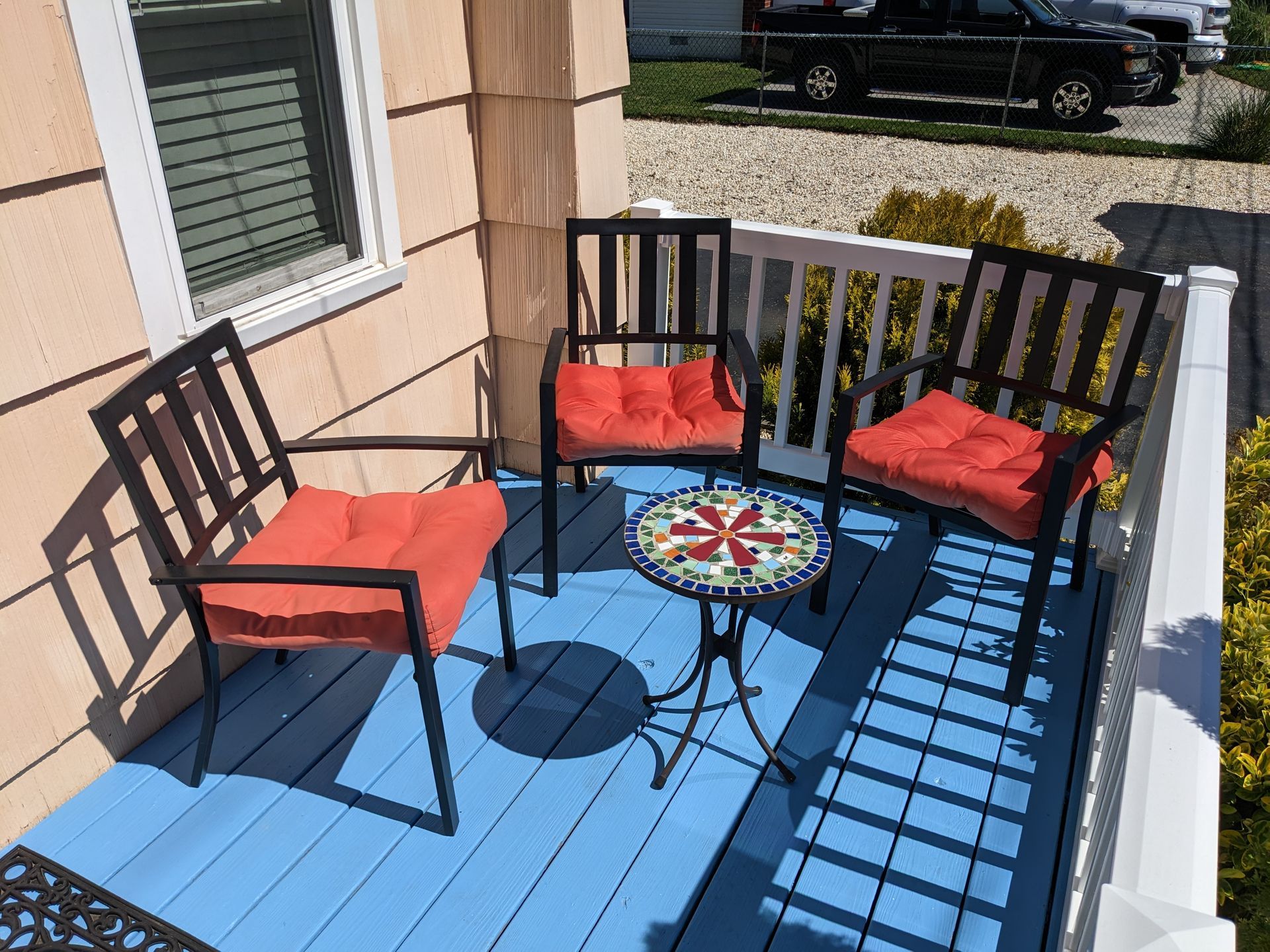 A blue deck with chairs and a table on it