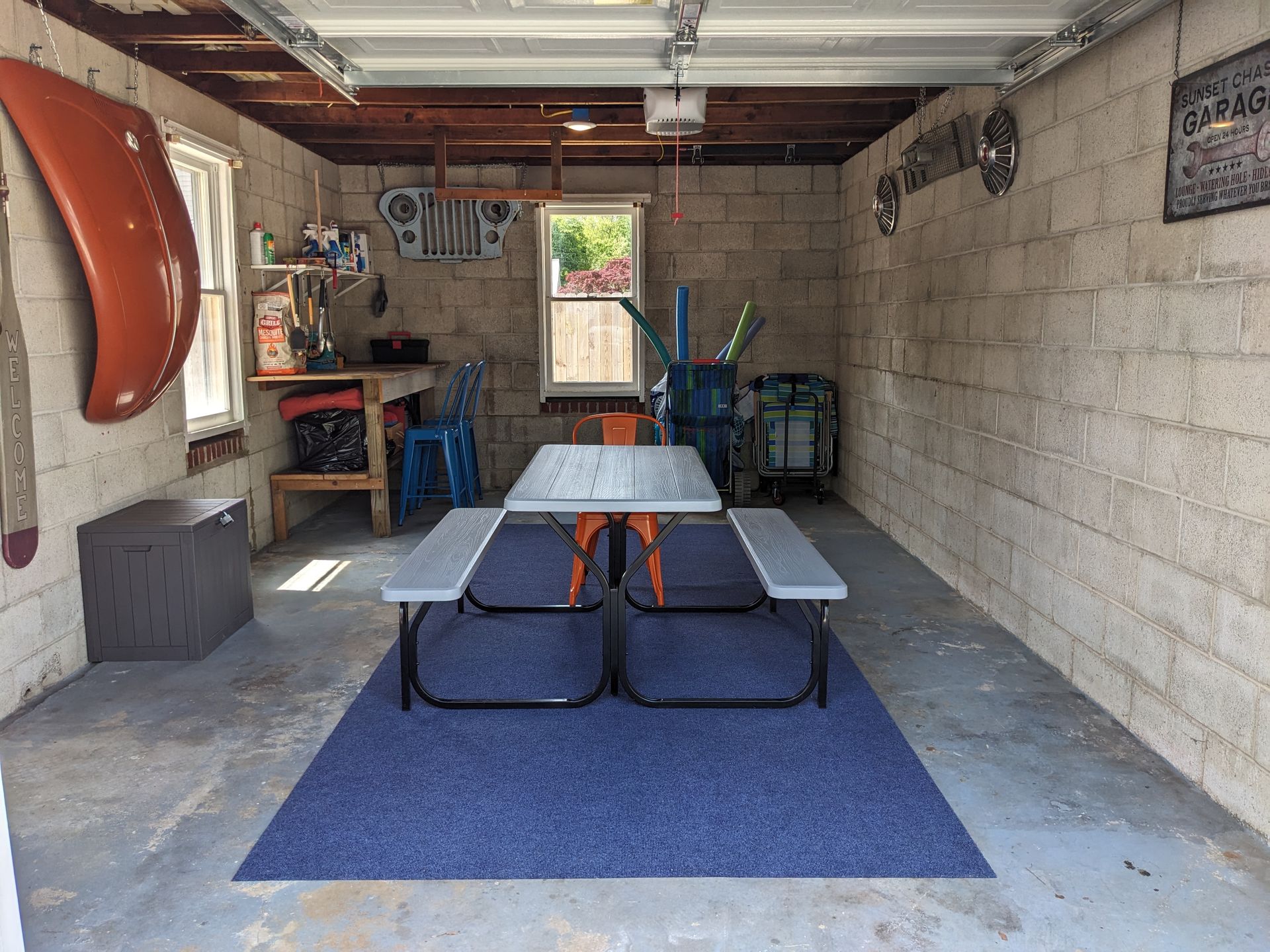 A garage with a picnic table and benches in it.