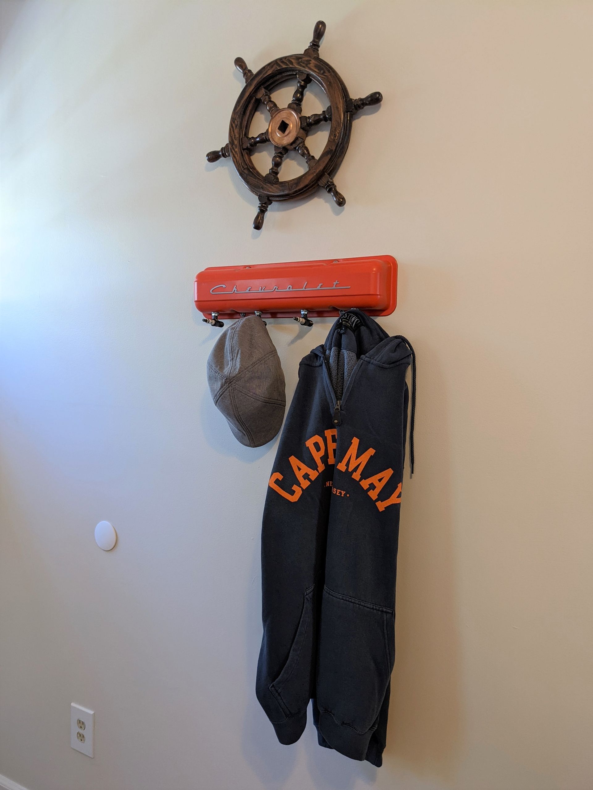 A cape may sweatshirt is hanging on a hook